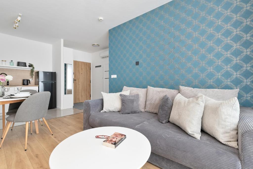 a living room with a couch and a table at Pino Resort Gdańsk by Solarento in Gdańsk