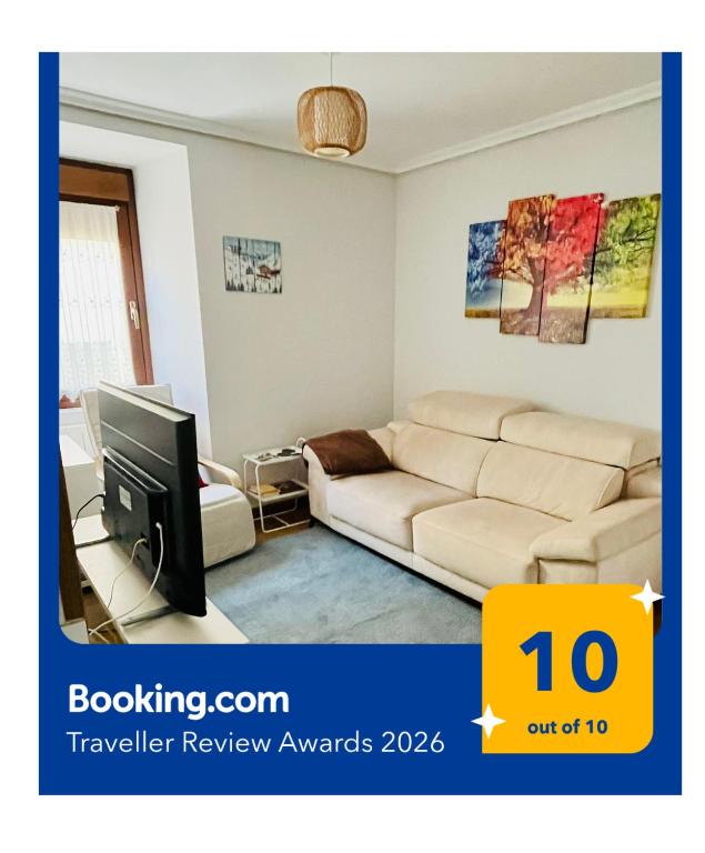 a living room with a couch and a tv at Acogedor apartamento parque Aizkorri-Aratz a 45 min San Sebastian in Araya