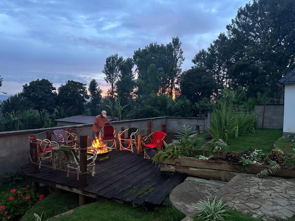 a man sitting around a fire on a wooden deck at Meru Nest Arusha in Arusha