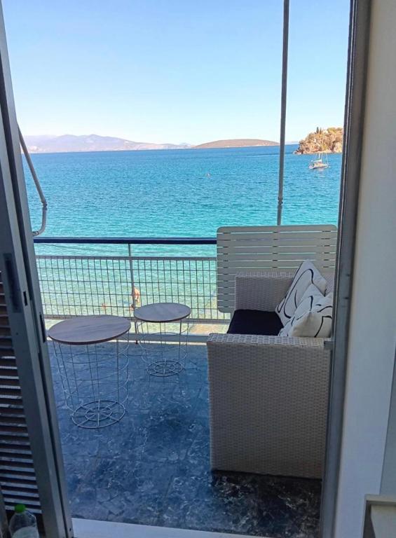 a balcony with a view of the ocean with tables and chairs at Tolo in Tolo