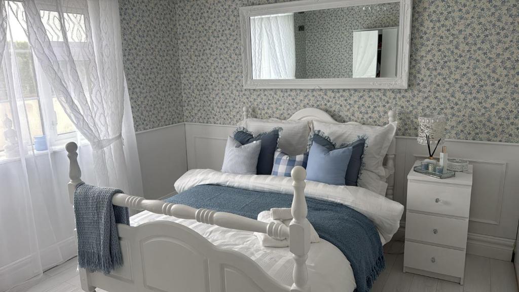 a bedroom with a bed with blue pillows and a mirror at Dernvale House -Double Room sleeps 2 in Mullinderg
