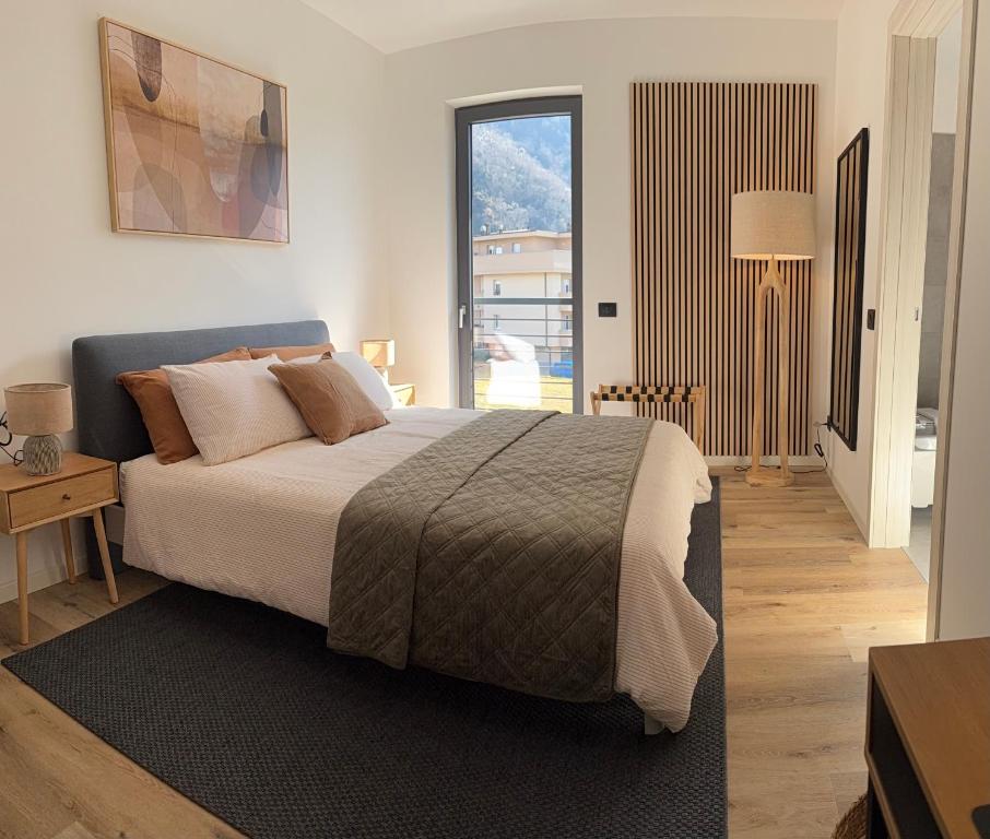 a bedroom with a large bed and a large window at CT Executive Rooms, Lake Como and Valtellina in Dubino