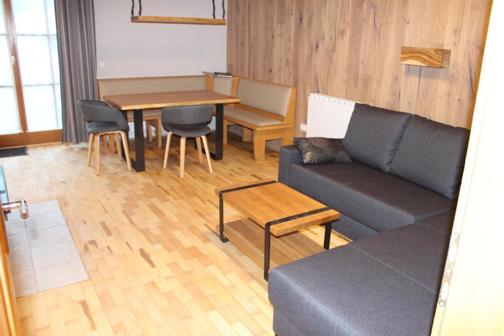 sala de estar con sofá, mesa y sillas en Apartment Appohorje, en Hočko Pohorje