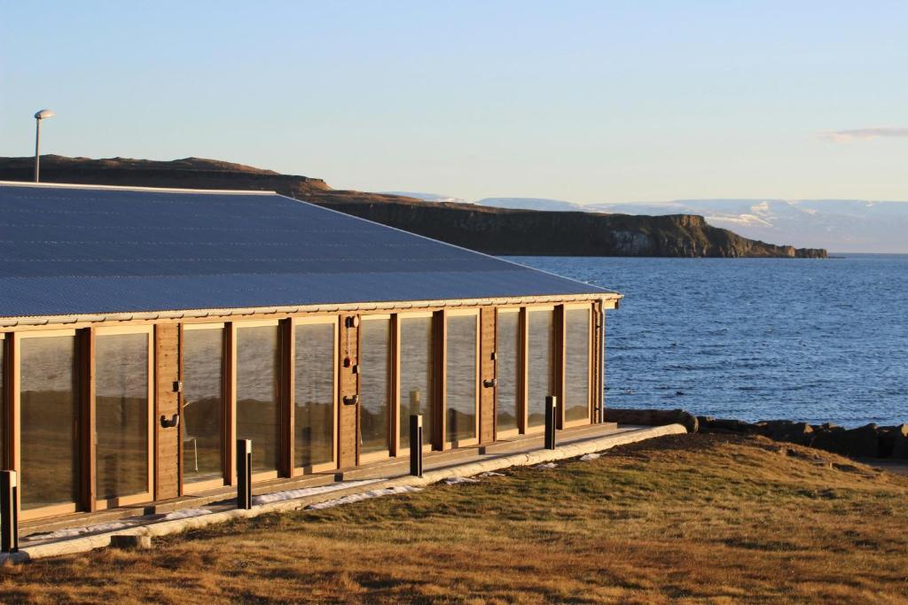 a building on the side of a body of water at Malarhorn Accommodations in Drangsnes
