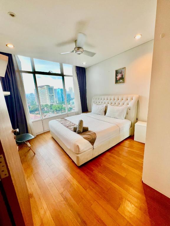 a bedroom with a white bed and a large window at Apartment klcc area in Kuala Lumpur