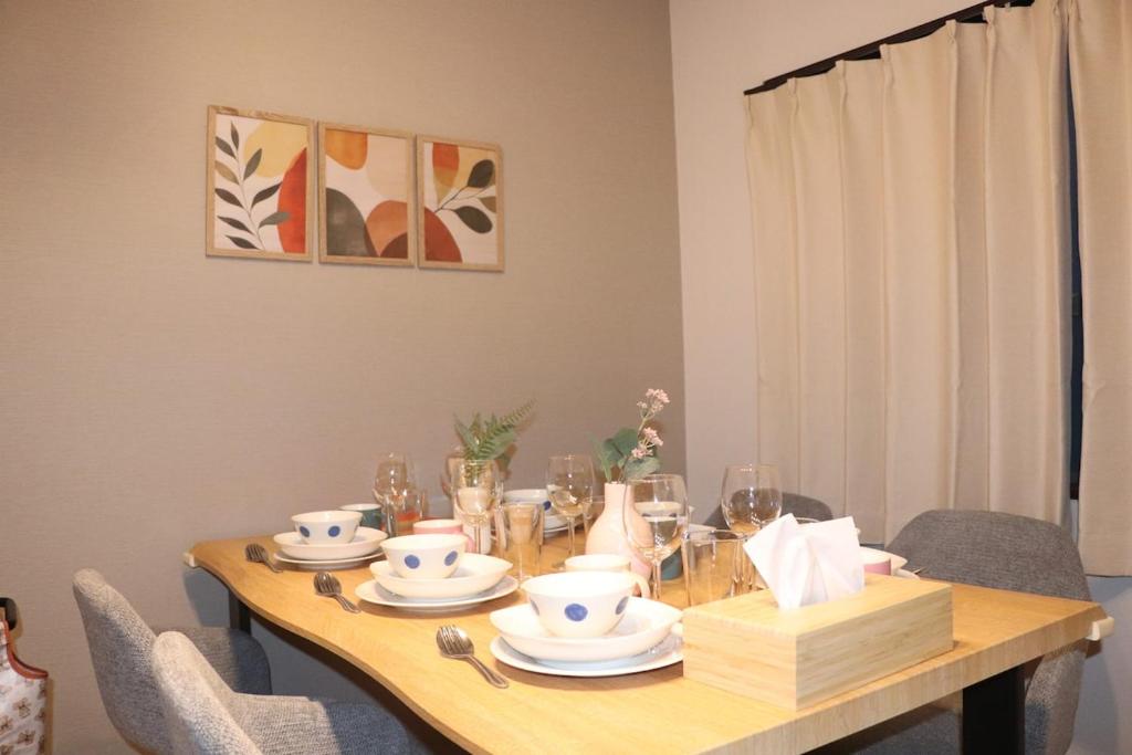 a dining room table with plates and dishes on it at 名古屋駅 中部国際空港近くの宿ひろし in Nagoya