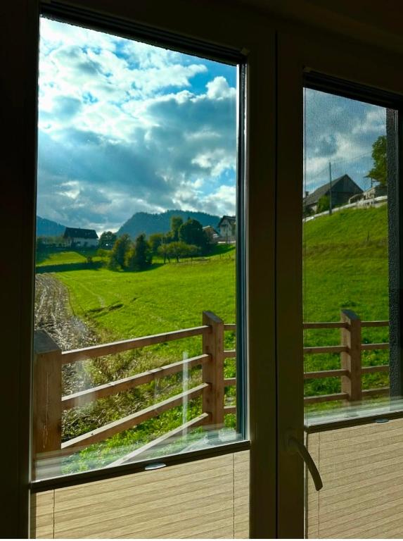 a window with a view of a green field at Mountain Paradise Apartment in Zgornje Gorje