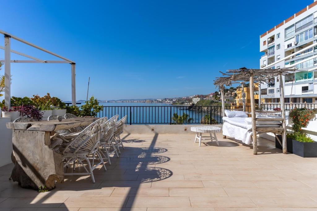 a row of chairs and tables on a roof at Dúplex Paradise above the sea in Benalmádena