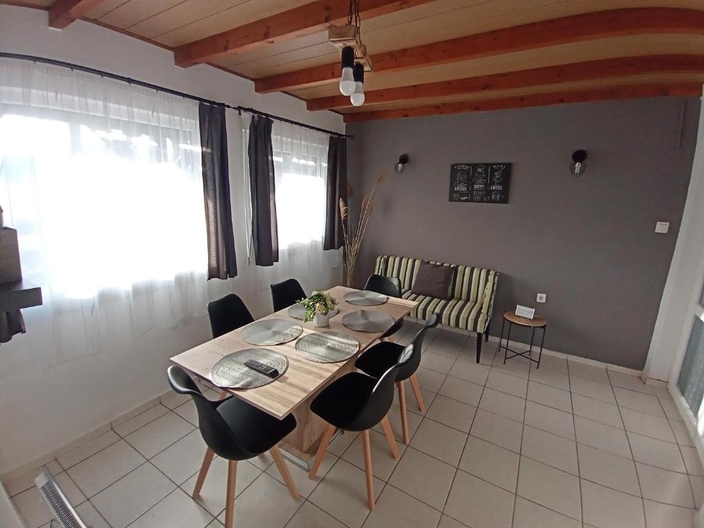 a dining room with a table and chairs in a room at Plázs Vendégházak 1 ,2 in Tiszafüred