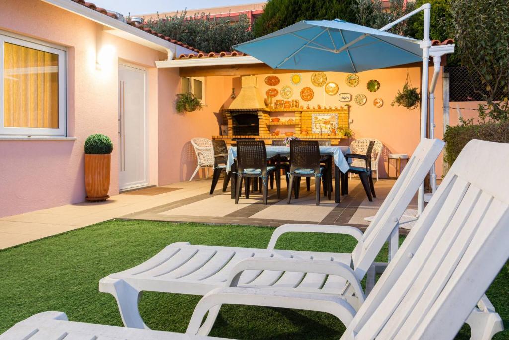 a patio with a table and chairs and an umbrella at Near beach and Oporto in Vila Nova de Gaia