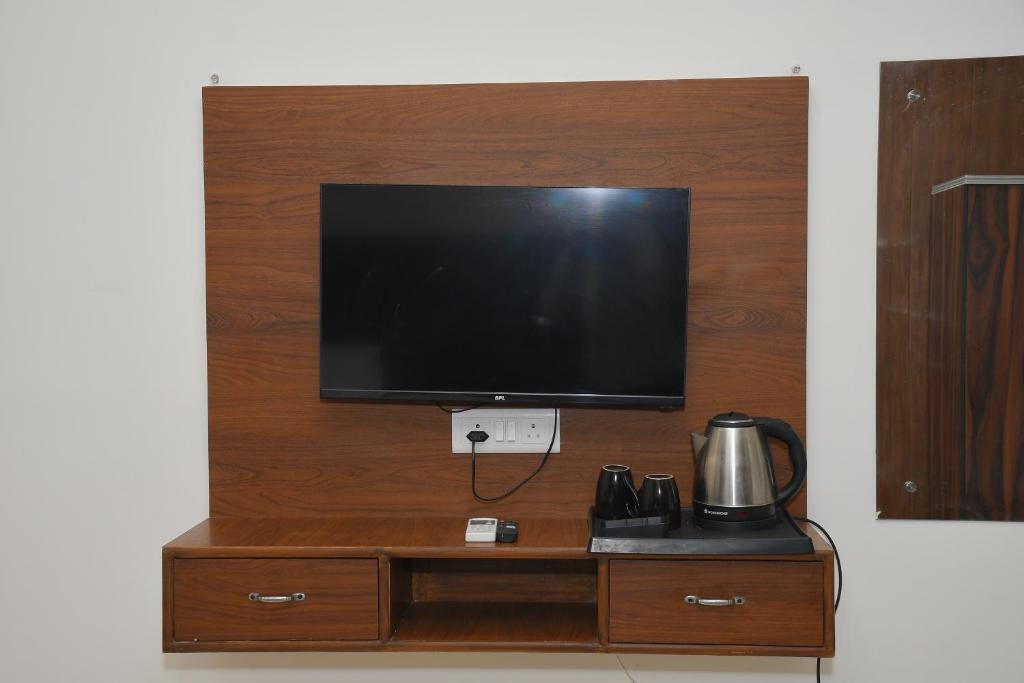 a flat screen tv on top of a wooden wall at The Ora Hotel in Vrindāvan