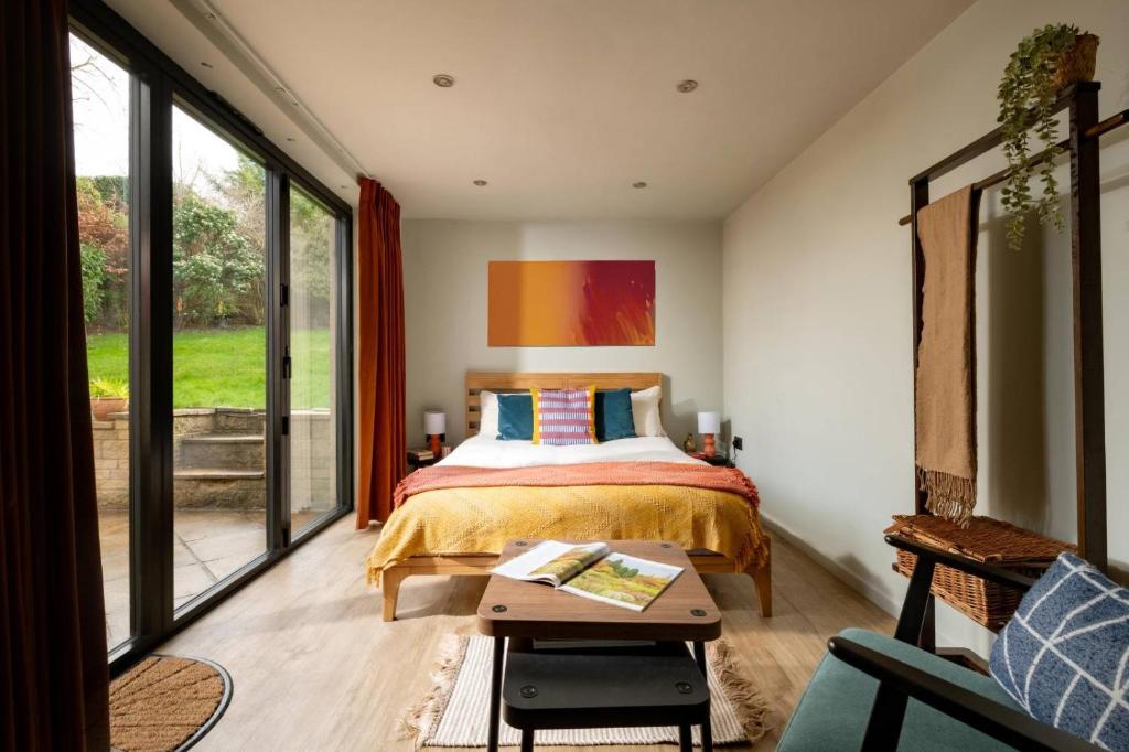 a bedroom with a bed and a table at Cotswolds Cabin in Stonesfield