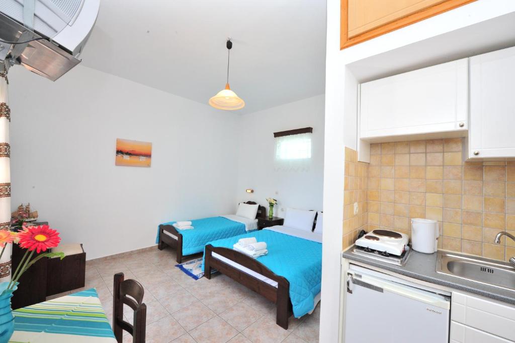a kitchen and a living room with a bed in a room at Pension Sofia Amorgos-Katapola in Katapola