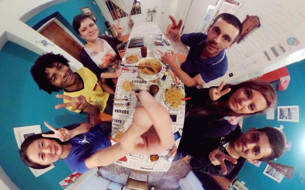 a group of people standing around a table in a kitchen at Wayra Hostel in La Rioja
