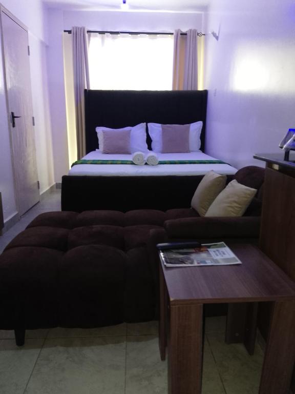 a living room with a couch and a bed at Serenity Brown Pad in Kiambu