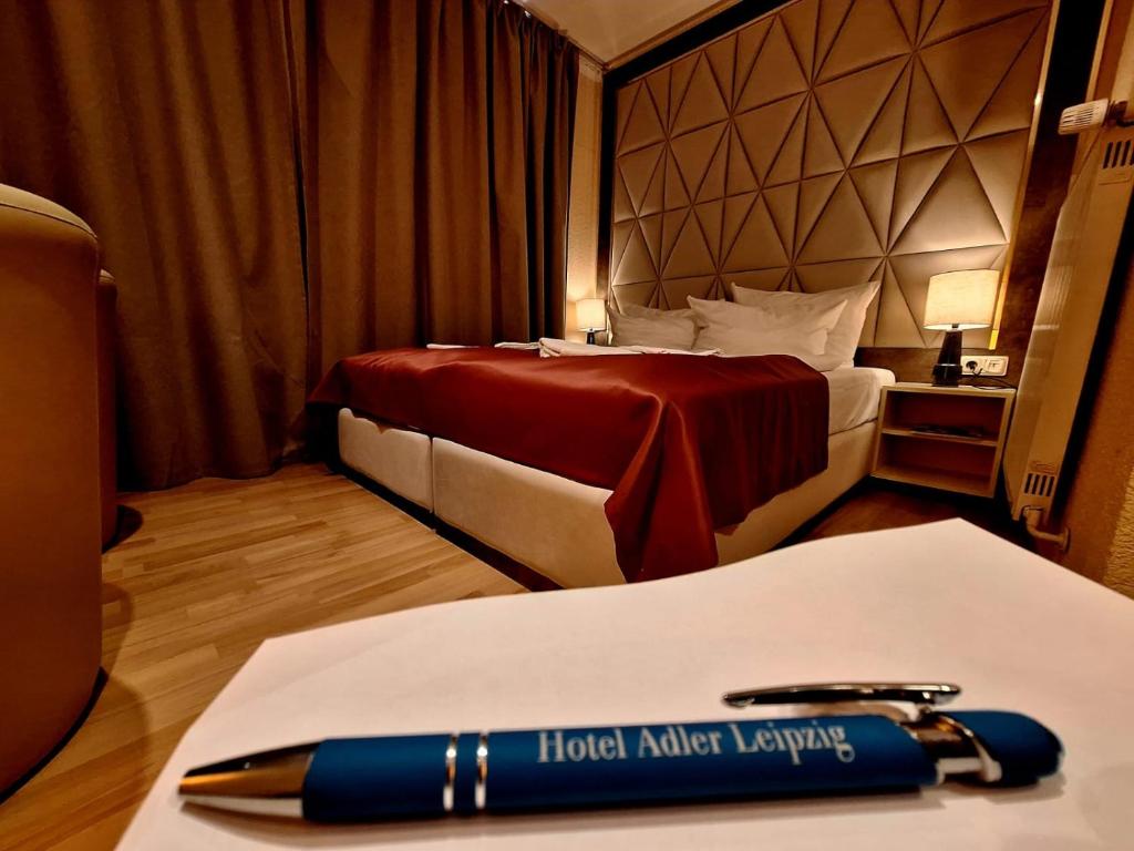 a room with a hotel harriott laptop and a pen on a table at Hotel Augustin Komfort Leipzig in Leipzig