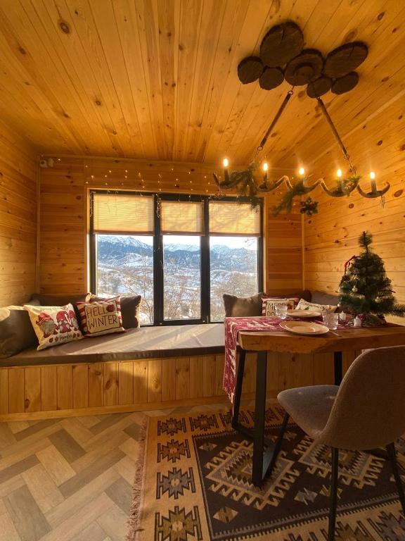 a room with a bed and a table in a cabin at Kainar Glamp Домик в горах с террасой и прекрасным видом на горы in Besqaynar