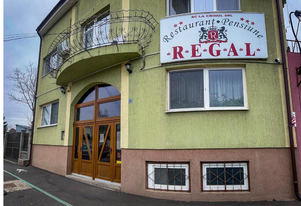 a green building with a sign for a restaurant at Pension Regal in Satu Mare