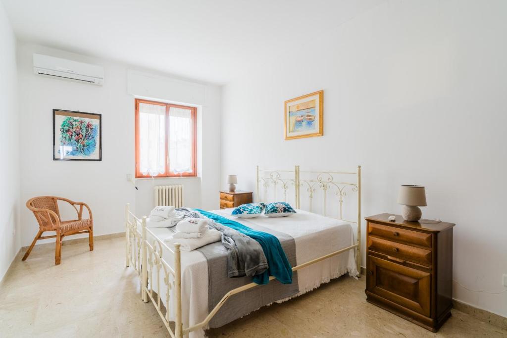 a bedroom with a bed and a chair and a dresser at Casa Stella Otranto Centre - Sea View, AC & WiFi in Otranto