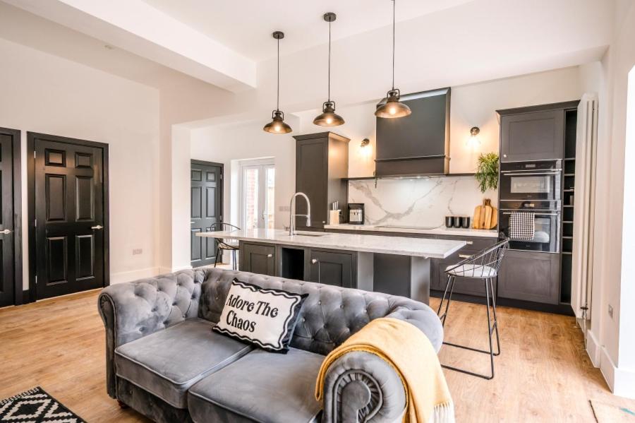 a living room with a couch and a kitchen at The Leiston, Valley Road in Leiston