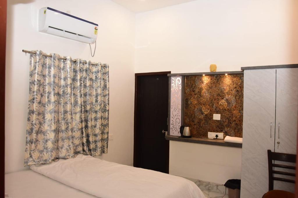 a bedroom with a bed and a curtain at Hotel Maa Karni Darbar in Deshnoke