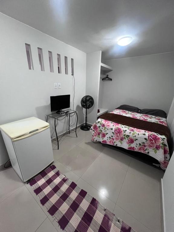 a bedroom with a bed and a desk and a computer at Pousada 705 norte 1 in Brasília