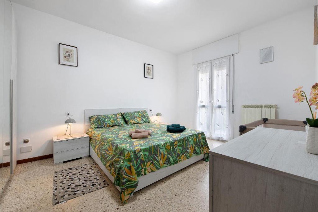 a white bedroom with a bed and a table and a bed sidx sidx at A due passi dalle terme e dal lago in Trescore Balneario