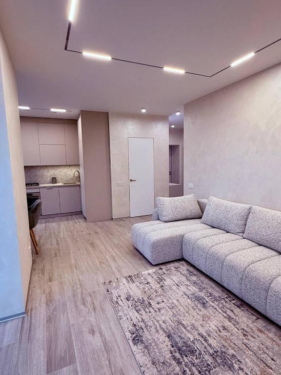 a living room with a couch and a kitchen at Центр стадіон Central Сity Замкова in Rivne