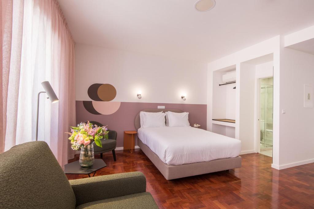 a hotel room with a bed and a couch at LSA Campos by Numa in Lisbon