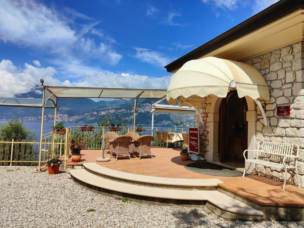 a house with a patio with a table and chairs at Residence Casa Maria in Assenza di Brenzone