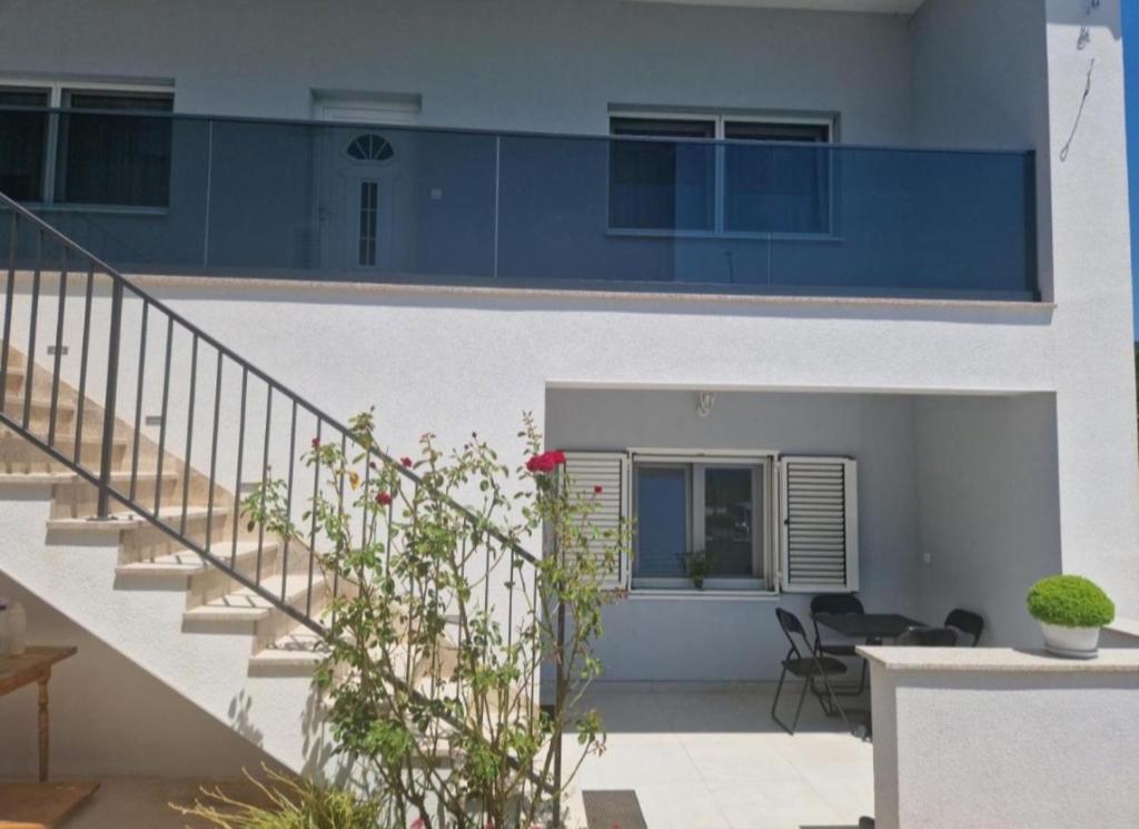 a white building with a staircase in a yard at MATEA Stay Imotski, Near Blue & Green Lake in Topići