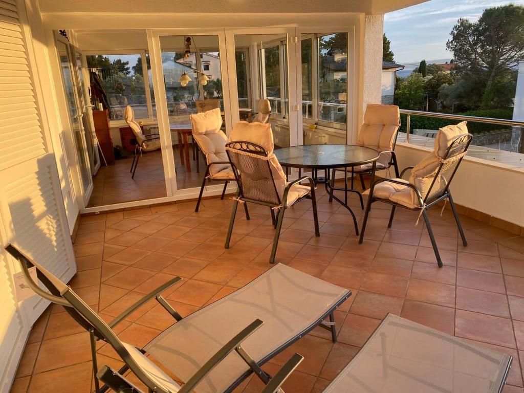 a screened in porch with a table and chairs at Sea side Punat in Punat
