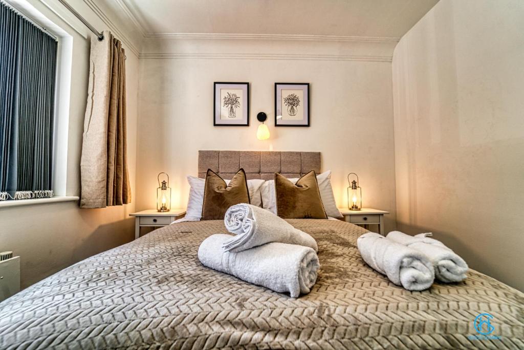 a bedroom with a large bed with towels on it at 4 Bedrooms- Sleeps 8 in Kidderminster