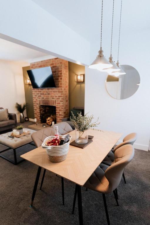 a living room with a table and a fireplace at Meldon Cottage with Private Hot Tub in Newbiggin-by-the-Sea