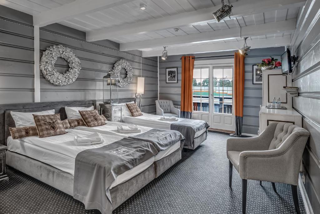 a bedroom with two beds and two chairs at Zajazd Plan in Wolbórz