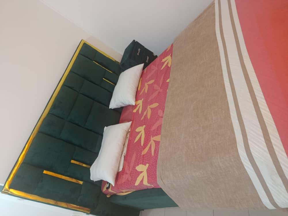 a group of pillows on a bed in a room at Chambre aménagée dans un hôtel in Douala