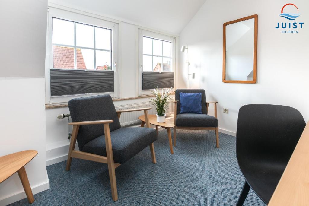 a waiting room with two chairs and a table and a mirror at Töwerland Zimmer 7 in Juist