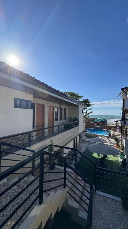 a building with a view of the ocean and a house at Elmarie Beach Resort in San Fabian