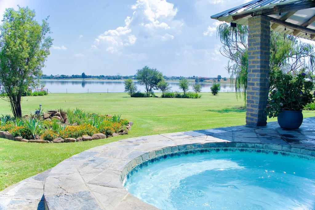 a swimming pool in a yard with a gazebo at Vaal Dam Manor - Waters Edge in Oranjeville