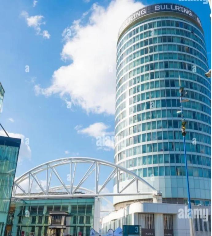 a tall glass building with a bridge in front of it at Birmingham Central NewStreet 1Bed in Birmingham