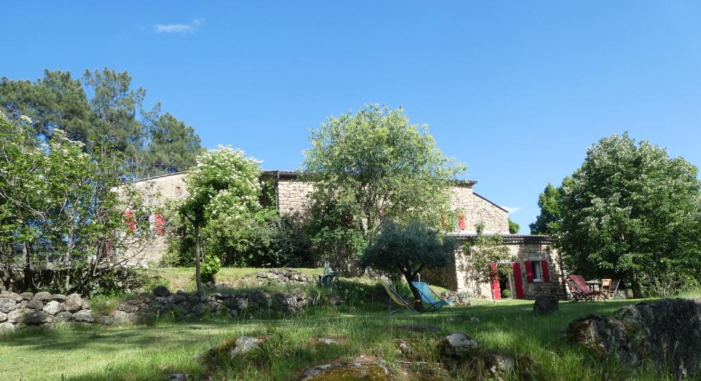 an old stone house with a garden in front of it at L'Oustalou in Rosières