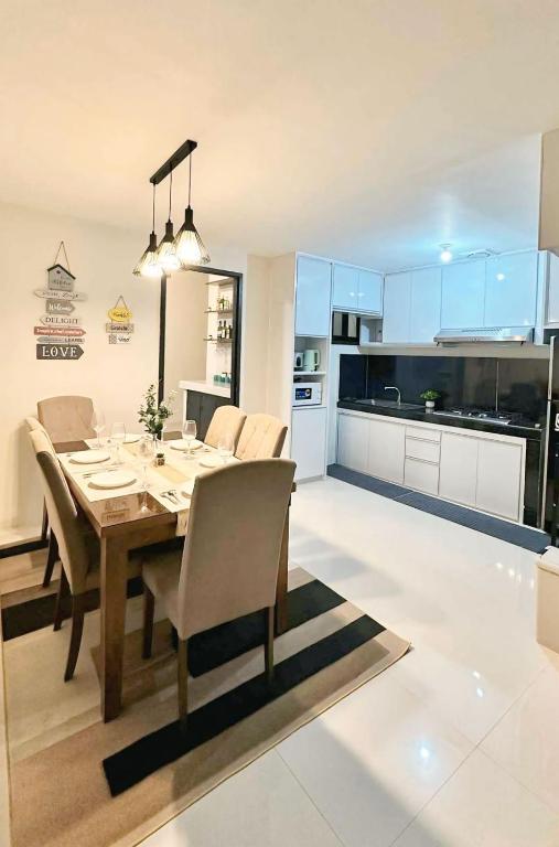 a dining room and kitchen with a table and chairs at Jumira Staycation in Tagum