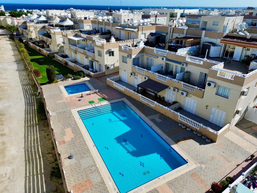 an aerial view of a villa with a swimming pool and houses at AquaSol Suite Modern 2BR with Shared Pool in Protaras