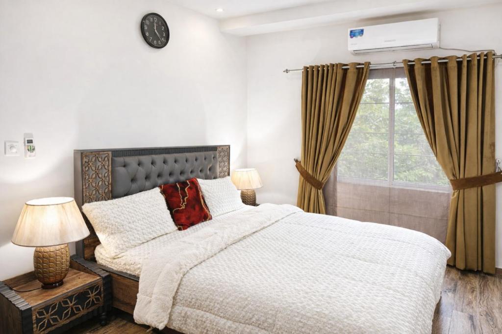 a bedroom with a bed and a window at Noir Escape Bahria hieghts D Block in Rawalpindi