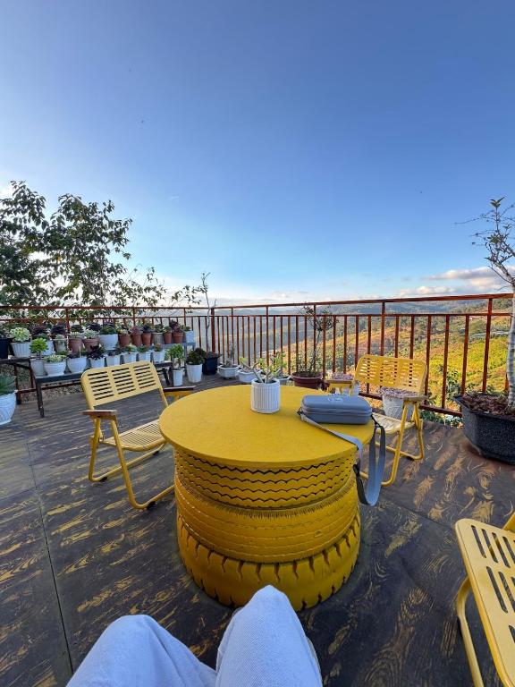 a yellow table and chairs on top of a balcony at Sen Đá Home 2 in Da Lat