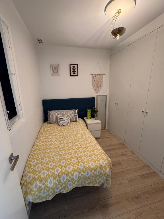 a bedroom with a bed with a yellow blanket at Habitación confortable en el centro in Valencia