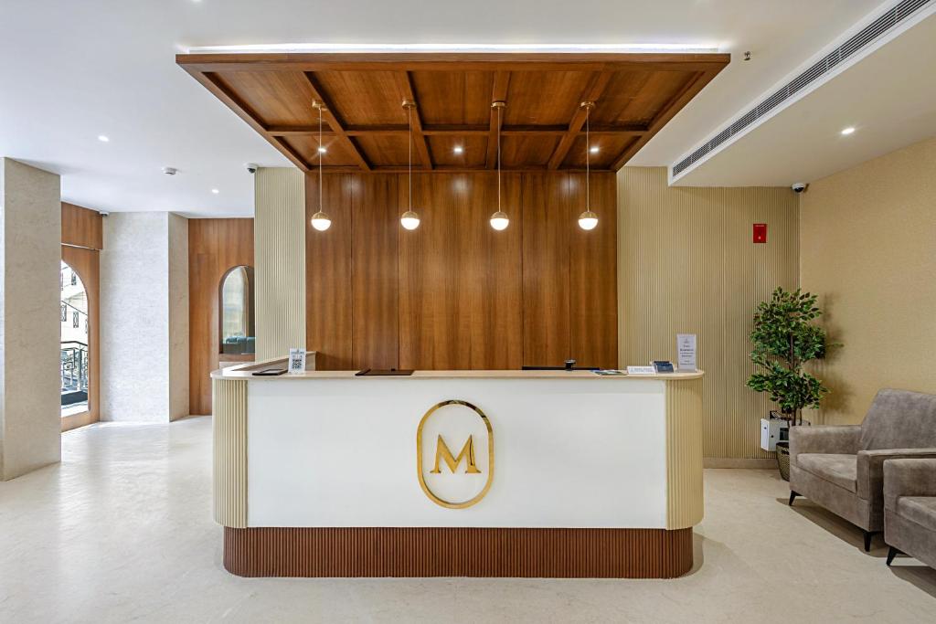 a lobby with a reception desk with a m logo at Monday Premium Madhapur in Hyderabad