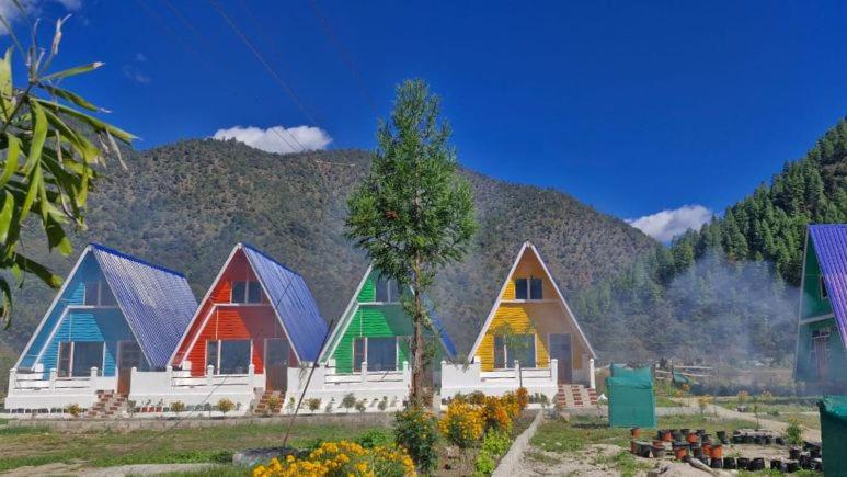 a row of colorful homes with a mountain in the background at Lanying Riverview Homestay in Dirang Dzong