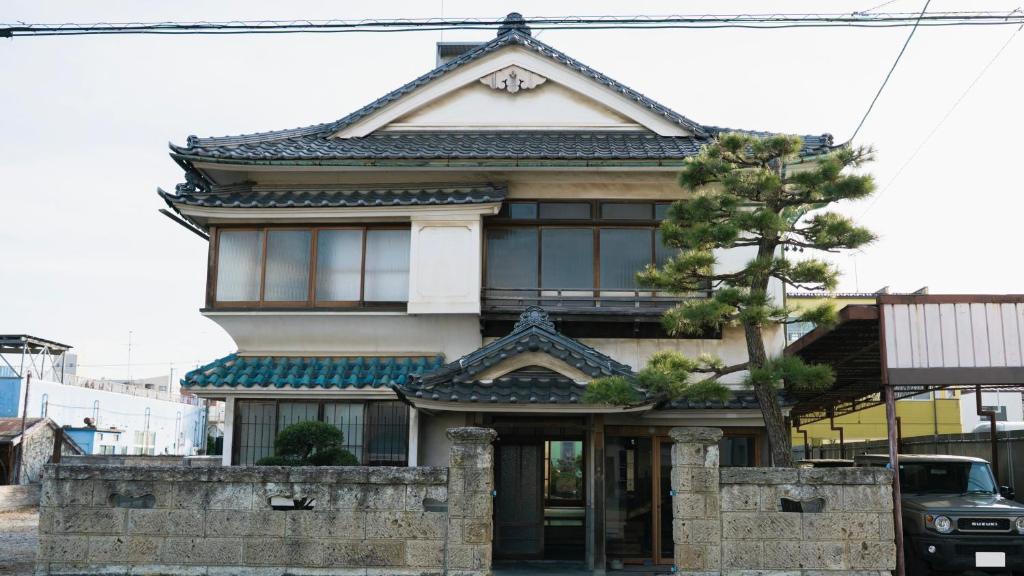 a building with an asian roof on a street at Guest House hopin in Nagano