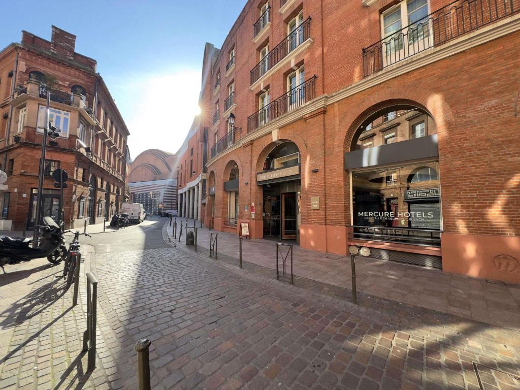 a cobblestone street in a city with buildings at Mercure Toulouse Centre Wilson Capitole in Toulouse
